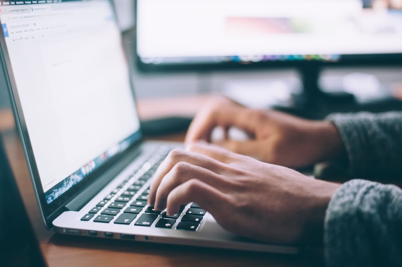An educator working on source material on a laptop